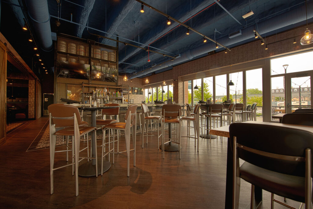 Main bar space with floor to ceiling retractable doors, TVs, and multiple seating arrangements at Fatpour Lincolnwood