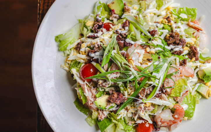 Coastal Cobb Salad - dungeness crab, shrimp, romaine, green cabbage, cherry tomato, olive mix, hard boiled egg, avocado, green onion, jalapeño aoli, herbed vinaigrette