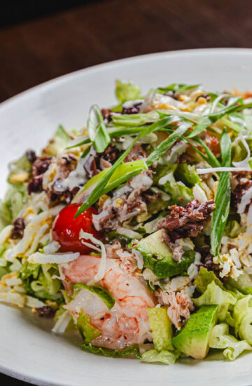Coastal Cobb Salad - dungeness crab, shrimp, romaine, green cabbage, cherry tomato, olive mix, hard boiled egg, avocado, green onion, jalapeño aoli, herbed vinaigrette
